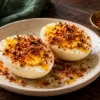Halved boiled eggs sprinkled with podi and a little oil