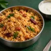 Bowl of podi rice with peanuts, curry leaves and plain curd