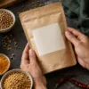 Hands holding an unbranded spice pouch beside bowls of spices