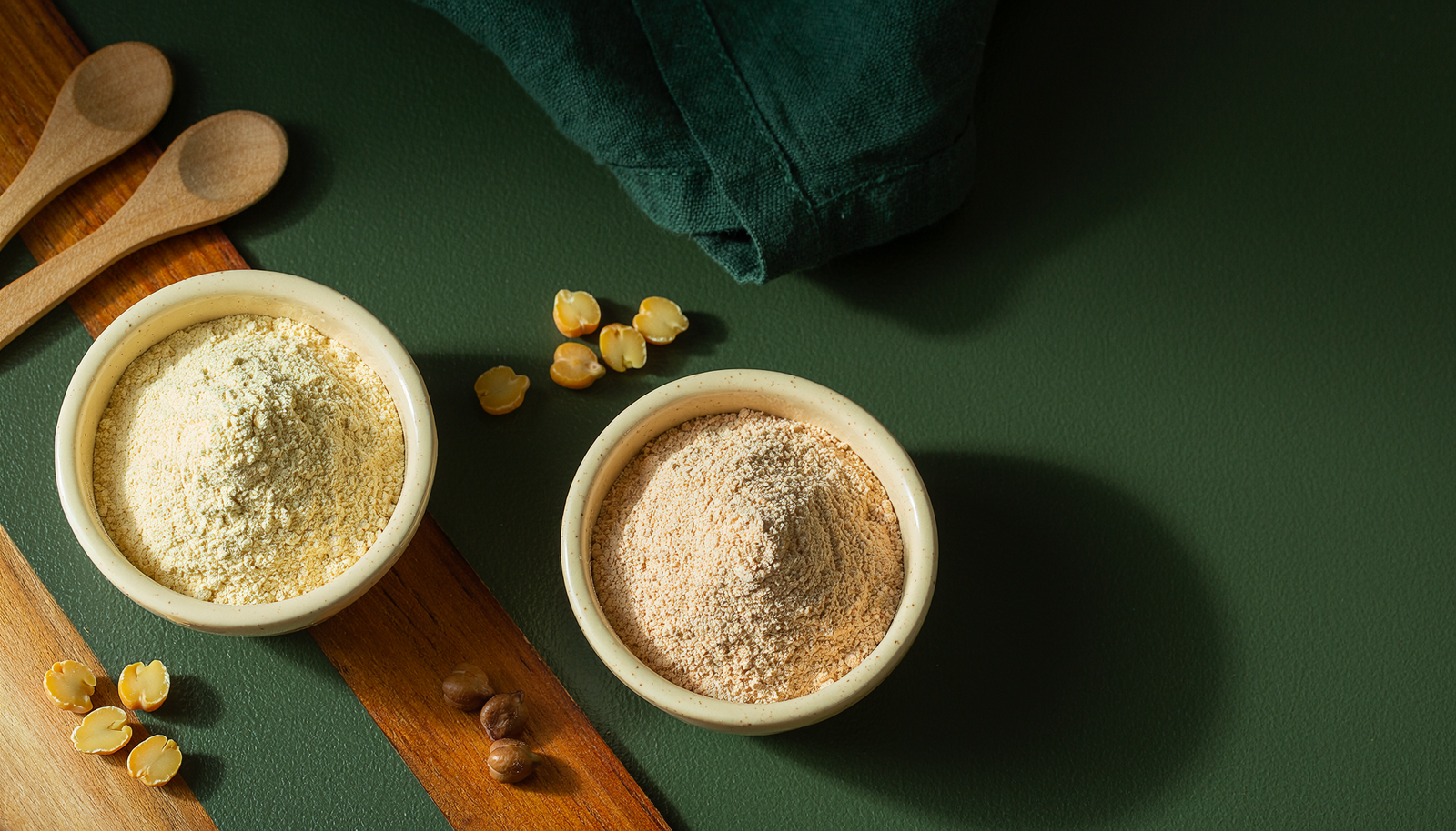 Overhead comparison of separate bowls of besan and roasted chana sattu.