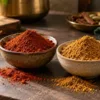 Two bowls of dark red and light brown masala powders