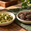 Small green cardamom pods beside larger ridged black cardamom pods