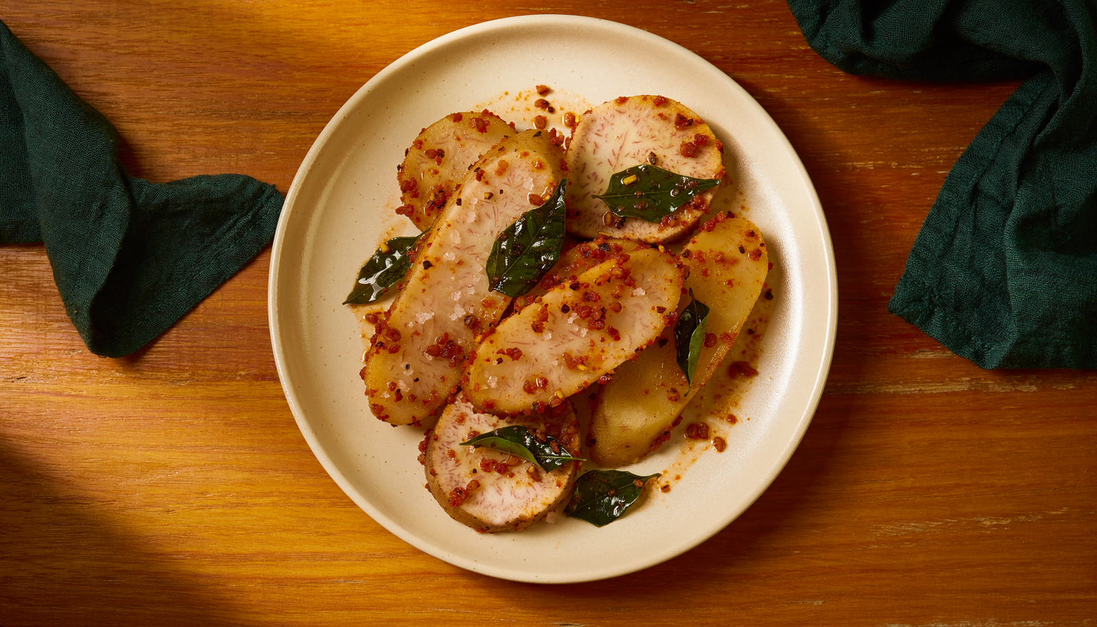 Close view of browned, cooked arbi slices with podi seasoning.