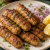 Cooked podi chicken seekh kebabs with lemon and onion