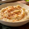 Soft rice-flour khichu topped with podi and a little oil