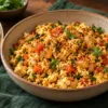 Bowl of podi paneer bhurji with onion and tomato beside roti